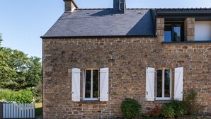 A stone building with two windows, a gravel driveway, and a small garden. - Charming House 'Au Pied Des Chênes' with Private Terrace, Shared Garden & Wi-Fi (Crach)