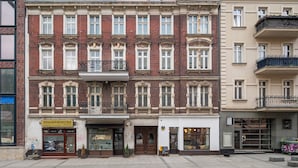 Un edificio de varios pisos con una tienda en la planta baja y un apartamento en el segundo piso.