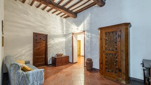 A room with a wooden bench, a cabinet, and a door. - Apartment 'Memories' Farm Stay with View of Siena (Monteroni d'Arbia)