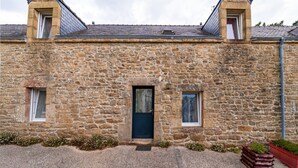 A stone building with a dark door, two windows, and a small garden area. - Cottage 'Le Cocon' with Private Terrace, Shared Garden and Wi-Fi (Crach)