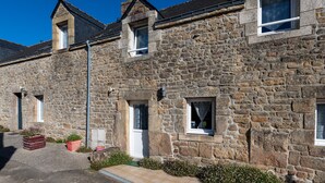 A stone building with multiple windows and a door, featuring a traditional architectural style.