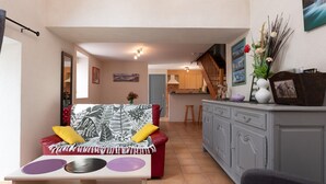 Ein Wohnzimmer mit Sofa, Couchtisch und einer Küche im Hintergrund.