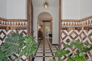 A hallway with a checkered floor, arched doorway, and decorative wall tiles. - Holiday Home 'Colina' with Mountain View, Private Terrace and Wi-Fi (Vejer de la Frontera)