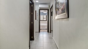 A hallway with a tiled floor, wooden doors, and a framed picture on the wall. - Holiday Home 'Pepi Sánchez Conil' with Private Terrace and Wi-Fi (Conil de la Frontera)