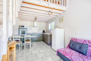 Una cocina compacta con comedor, un sofá y una ventana.