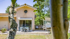 A building with a round window, a garage door, and a patio with outdoor furniture.