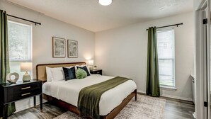 A bedroom with a bed, nightstands, a lamp, and two framed pictures on the wall. - Near Boone Pickens Stadium - Stillwater Stay (Stillwater)