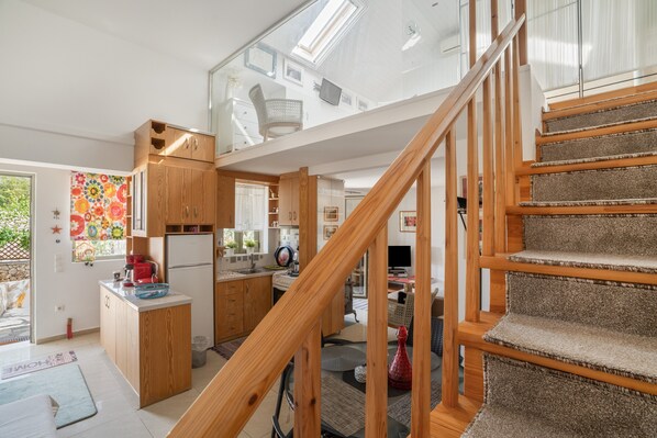 A modern kitchen with wooden cabinets, a built-in fridge, and a dining area with a table and chairs.