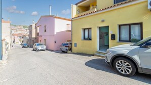 Una calle residencial con coches aparcados y casas.