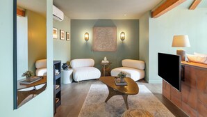 A modern living room with a sofa, coffee table, and TV. There are wall-mounted lights and a framed artwork above the sofa. - Escape to Sedona Demir Suite 205, a cozy 1-bed condo in vibrant Uptown Sedona! (Sedona)