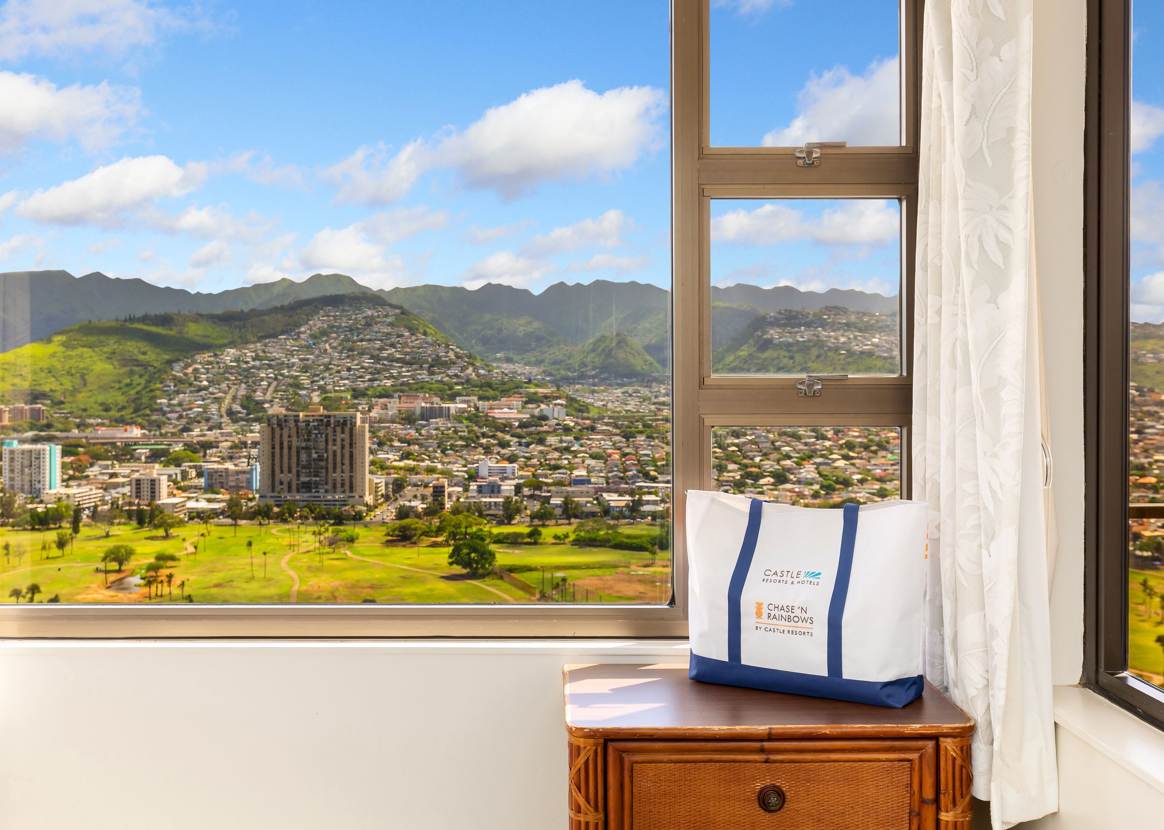 A view from a window with a bag labeled "Castle & Resorts" on a wooden nightstand.