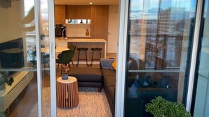 Um apartamento moderno com cozinha, área de refeições e sala de estar com sofá e mesa de centro.