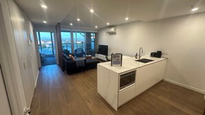 Um apartamento moderno com cozinha, sala de jantar e varanda com vista para a cidade.