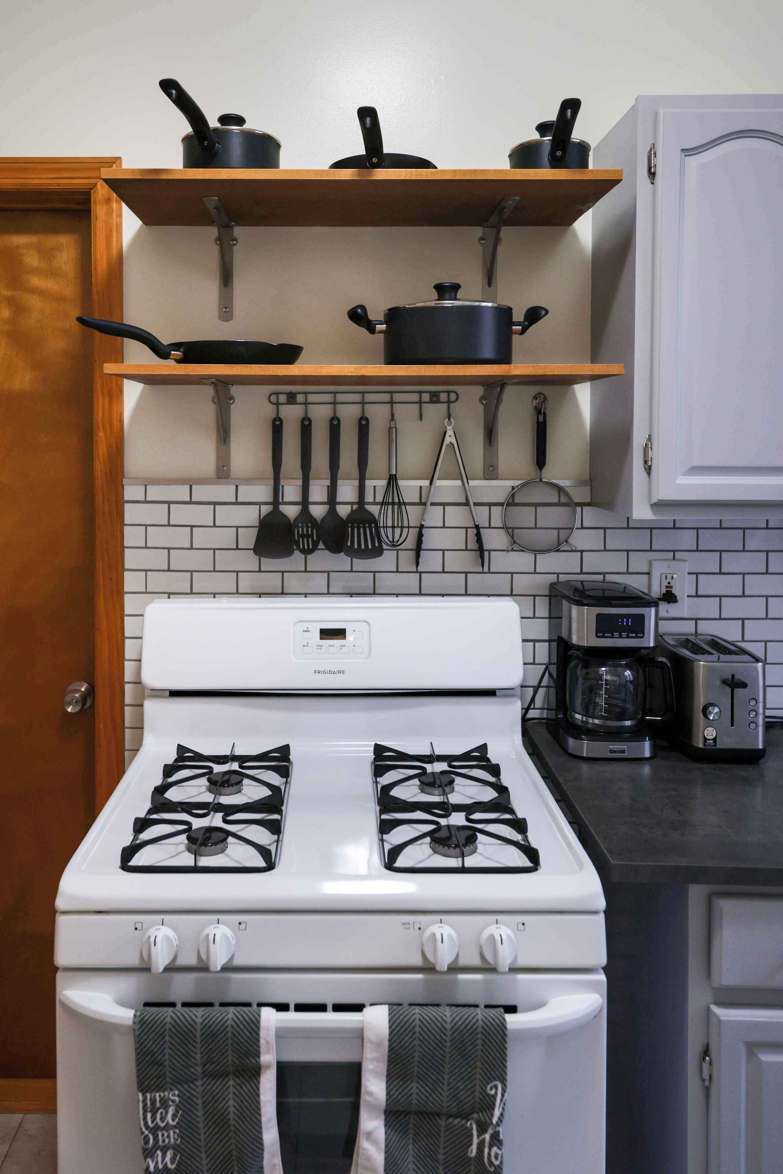 A kitchen with a white stove, a coffee maker, and a toaster on the counter.