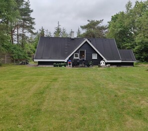 A house with a sloped roof, a front door, and a small porch area.