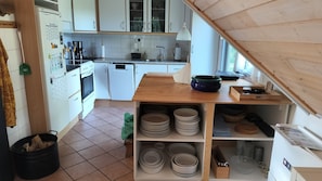 Eine KĂŒche mit weiĂen SchrĂ€nken, einer Holz Arbeitsplatte, einem Herd und einem SpĂŒlbecken.