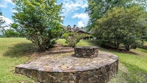 A stone circular structure in a grassy area with trees and a building in the background. - 6000 sq ft home with Private Pool and Hot Tub, Sleeps 16 - 13 Acres (Upatoi)