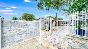 A gated entrance to a property complex with a sign reading "2819 Welcome Beach Life Properties." - Coastal unit! .5 miles to Beach! (Fort Lauderdale)