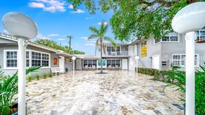 A courtyard with a stone floor, white walls, and satellite dishes. - Coastal unit! .5 miles to Beach! (Fort Lauderdale)