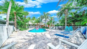 A pool area with lounge chairs, a small pool, and palm trees. - Tropical Paradise+ Pool & Patio! (Fort Lauderdale)