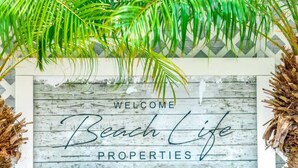 A welcome sign for Beach Life Properties with a rustic wooden background and palm fronds above. - Tropical Paradise+ Pool & Patio! (Fort Lauderdale)