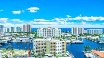 A high-rise hotel with multiple floors, a marina with boats, and a clear view of the ocean.