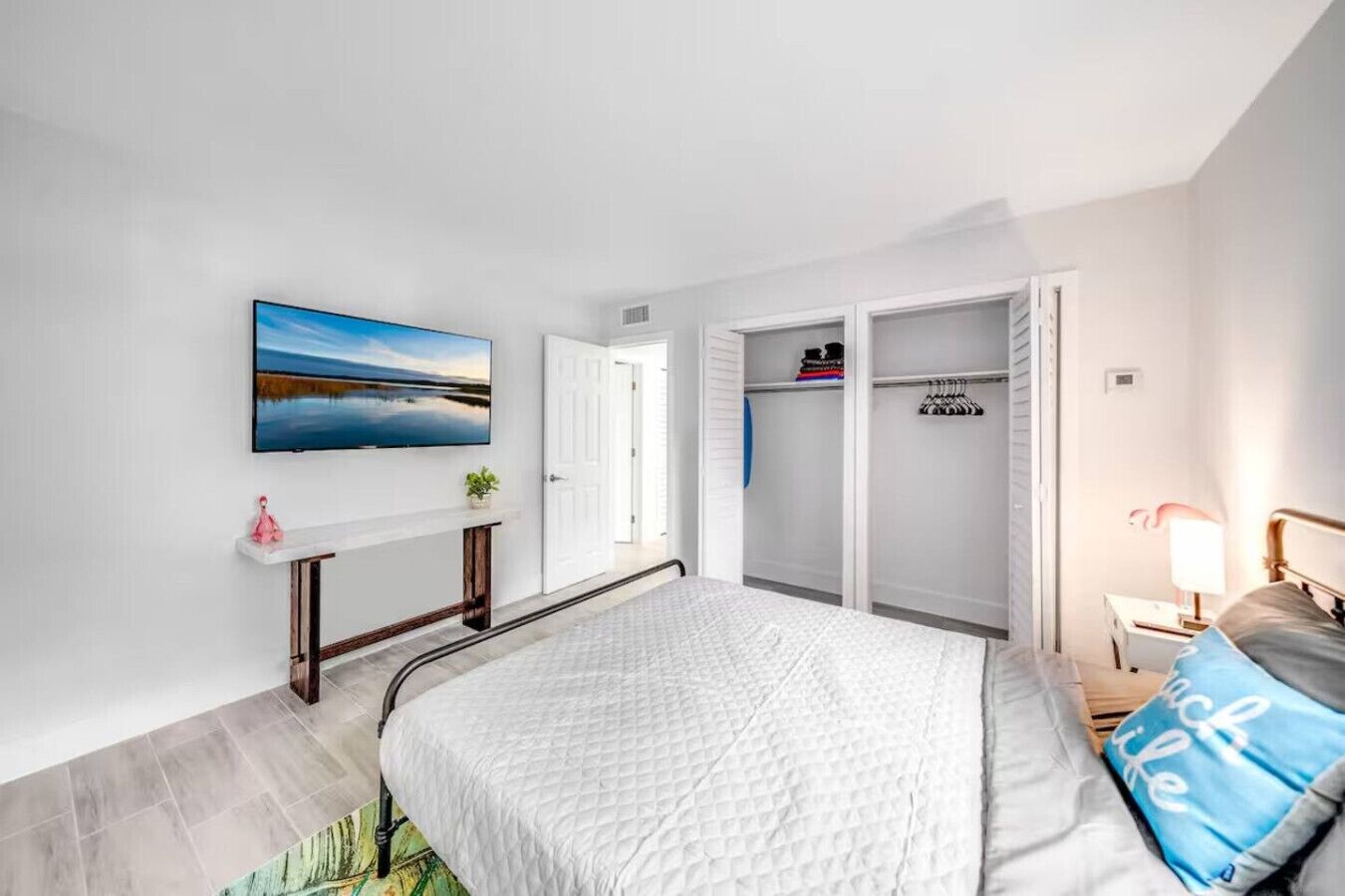 Une chambre à coucher avec un lit, une armoire, un bureau et un téléviseur fixé au mur.