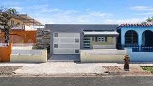 Una calle residencial con casas, un garaje y un hidrante.