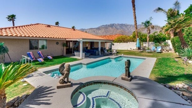 A house with a swimming pool, a covered patio, and a mountain view.