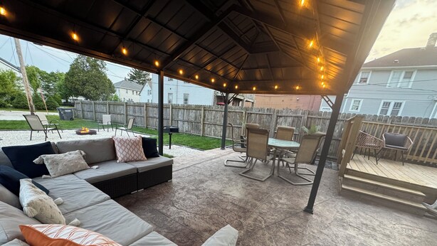 An outdoor patio with a covered seating area, a fire pit, and a table with chairs. - 4- Bedroom Retreat with Sauna, Game Room, Patio & Walk to Bars & Restaurants (Sheboygan)