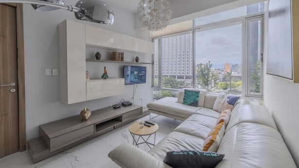 A modern living room with a large window, a sofa, a TV, and a decorative chandelier. - Apt with Reforma View - Pool and Jacuzzi (Mexico City)