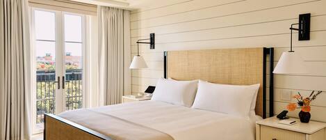Une chambre d’hôtel avec un lit, des tables de chevet, un ventilateur de plafond et une vue par la fenêtre.