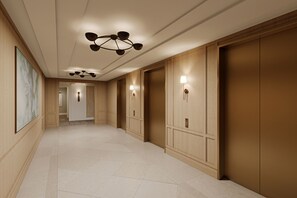A hallway with wooden paneling, a ceiling light fixture, and wall-mounted lamps. - The Cooper (Charleston)