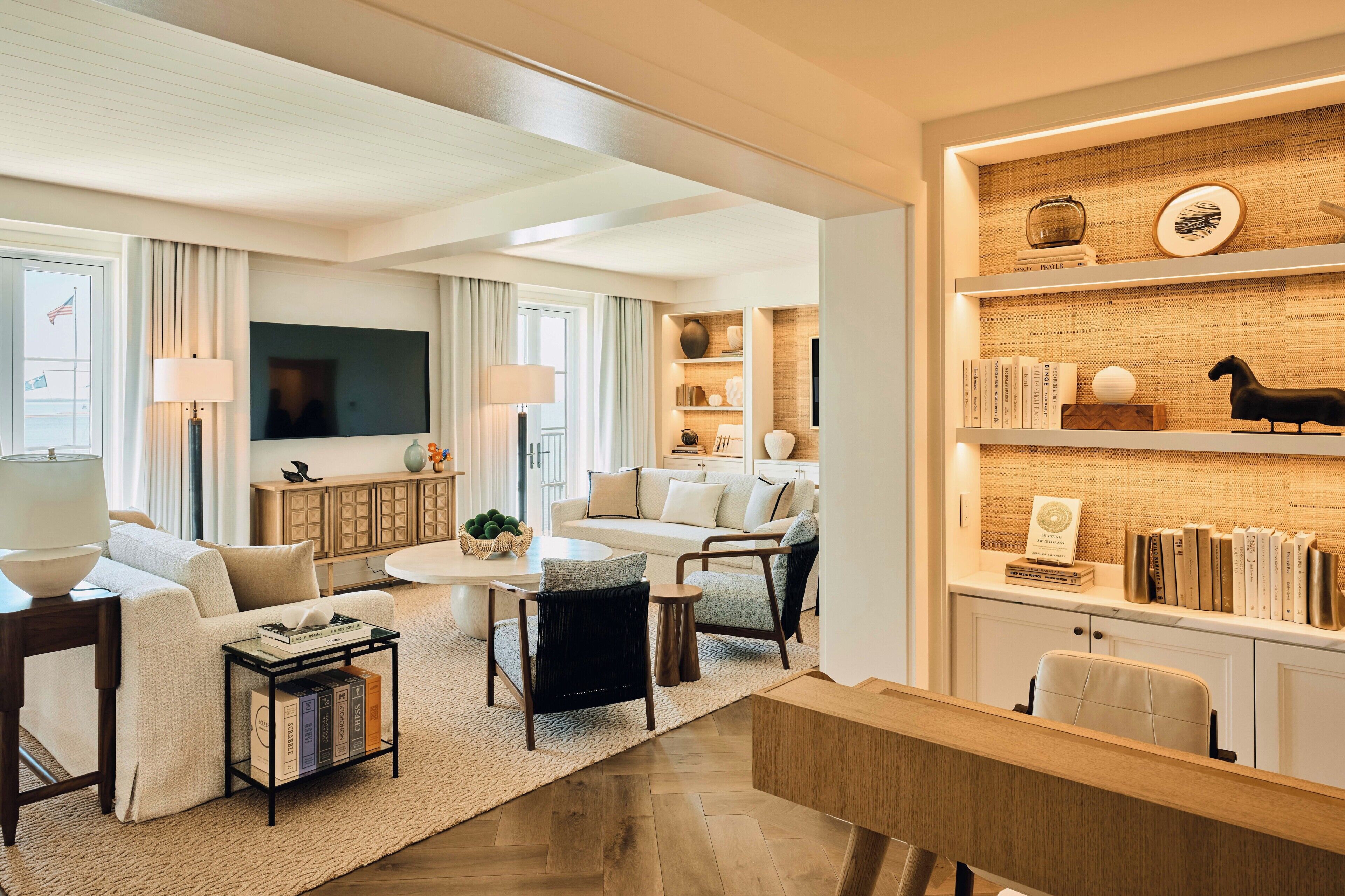 A modern living room with a sofa, coffee table, and bookshelves.
