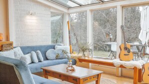 Una sala de estar acogedora con un sofá azul, una mesa de centro de madera y una guitarra.