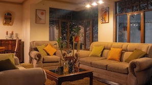 Uma sala de estar acolhedora com sofás, uma mesa de centro e um espaço de jantar com mesa e cadeiras de madeira.