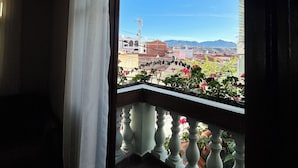 Uma varanda com vista para um horizonte urbano, incluindo edifícios e montanhas.