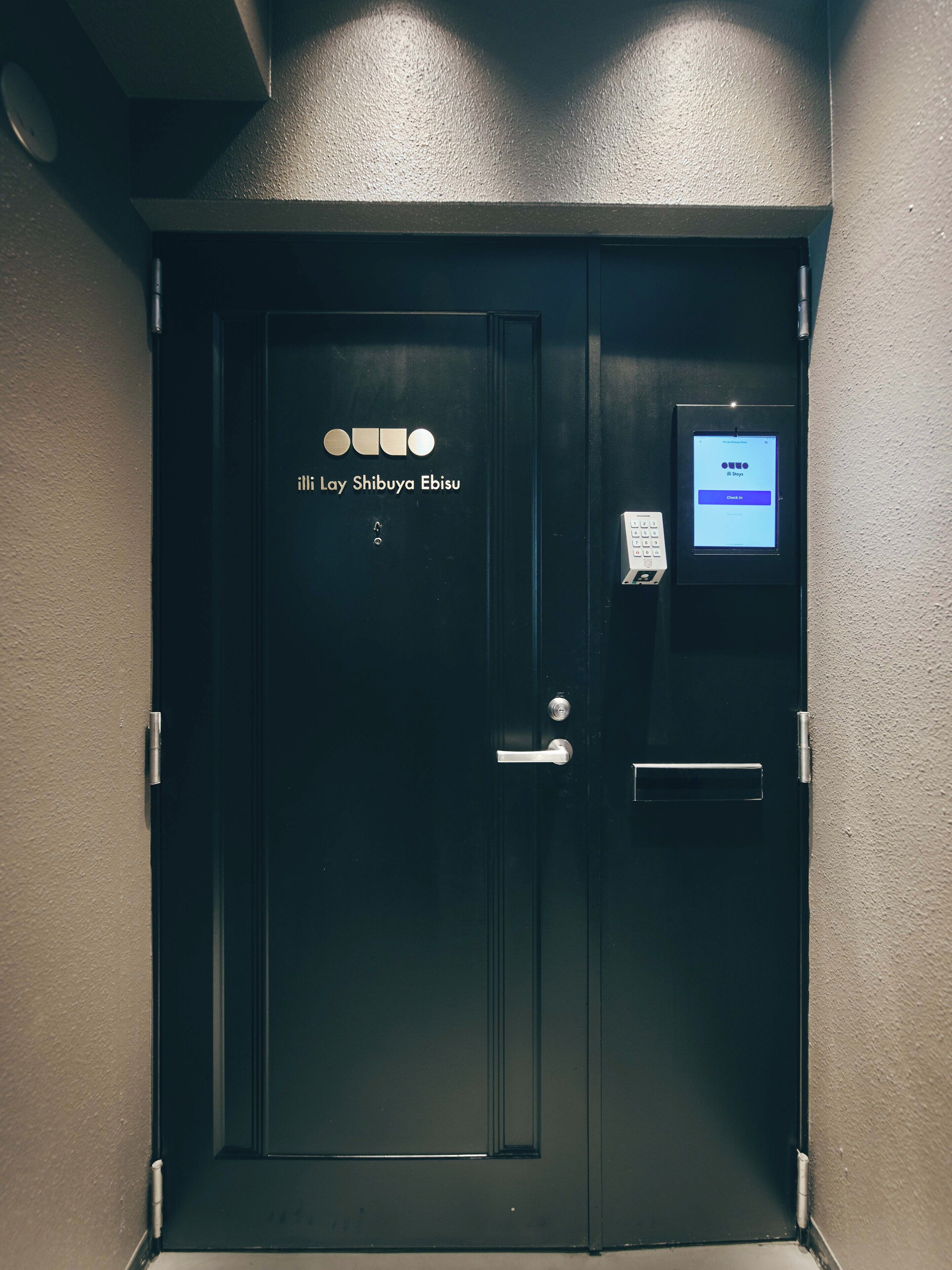 A black door with a digital keypad and a sign reading "iLLi Lay Shibuya Ebisu".