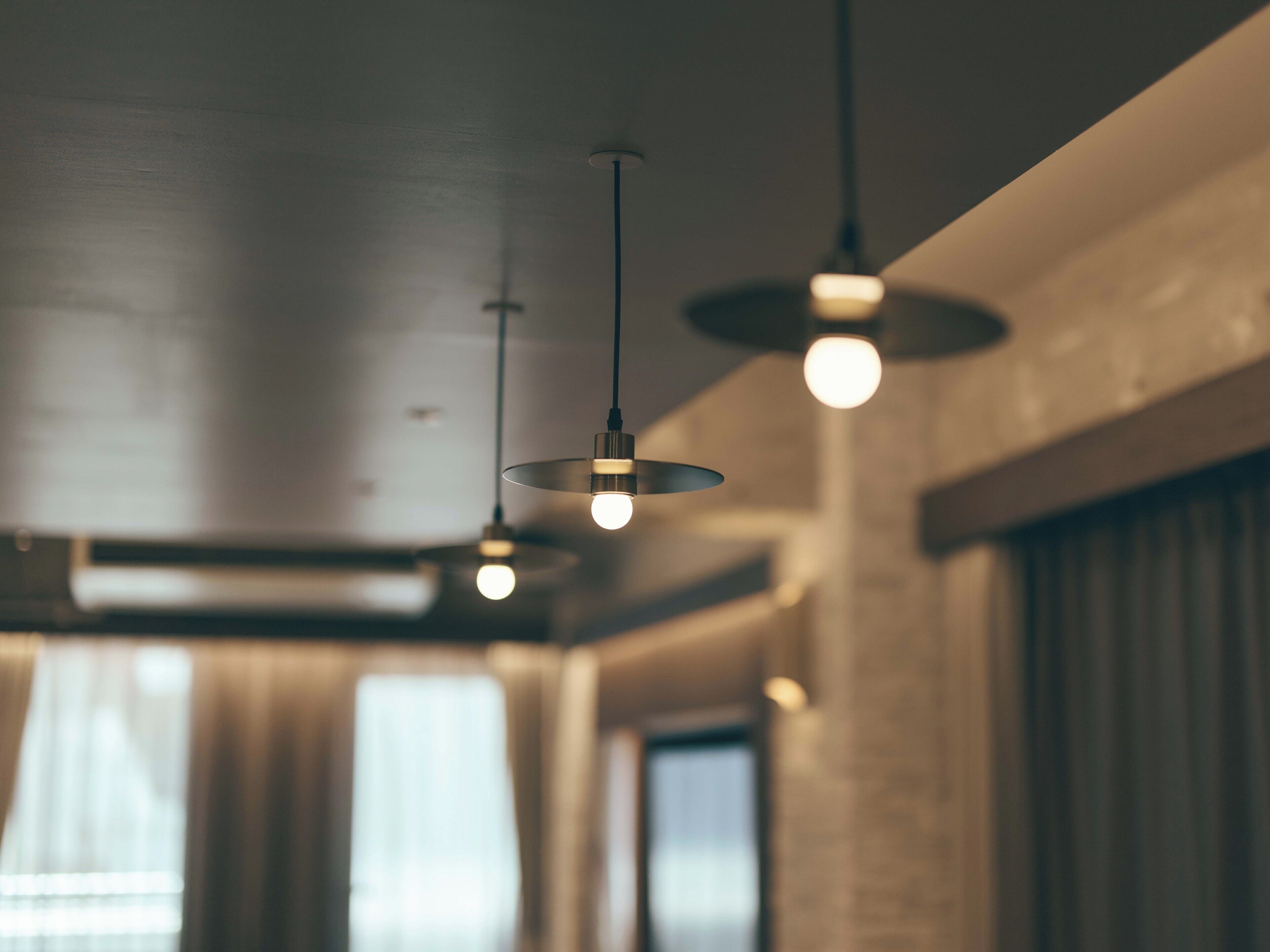 A modern interior with pendant lighting and large windows.
