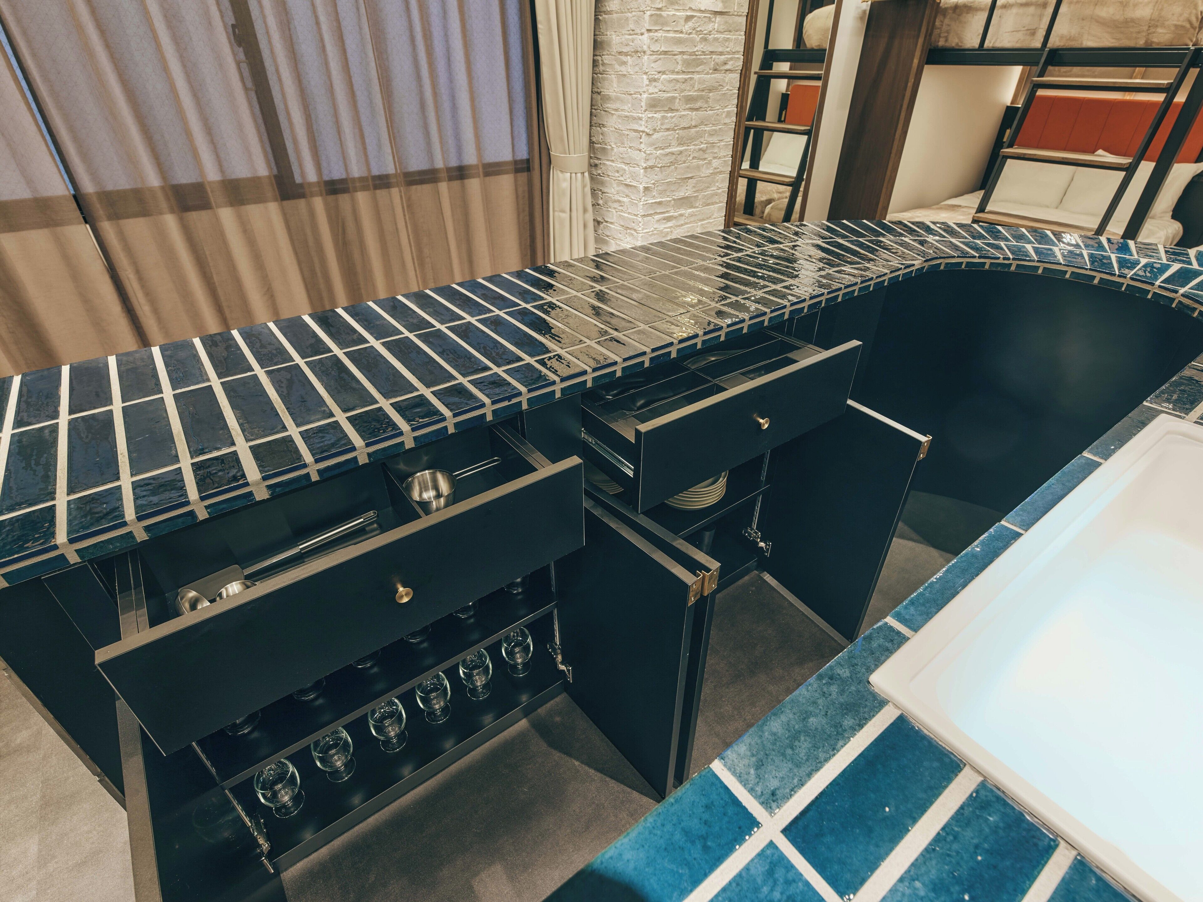 A kitchen with a black countertop, a stove, and a sink.