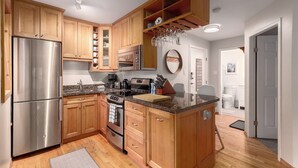 Une cuisine moderne avec des meubles en bois, des appareils en acier inoxydable et un plan de travail en granit.