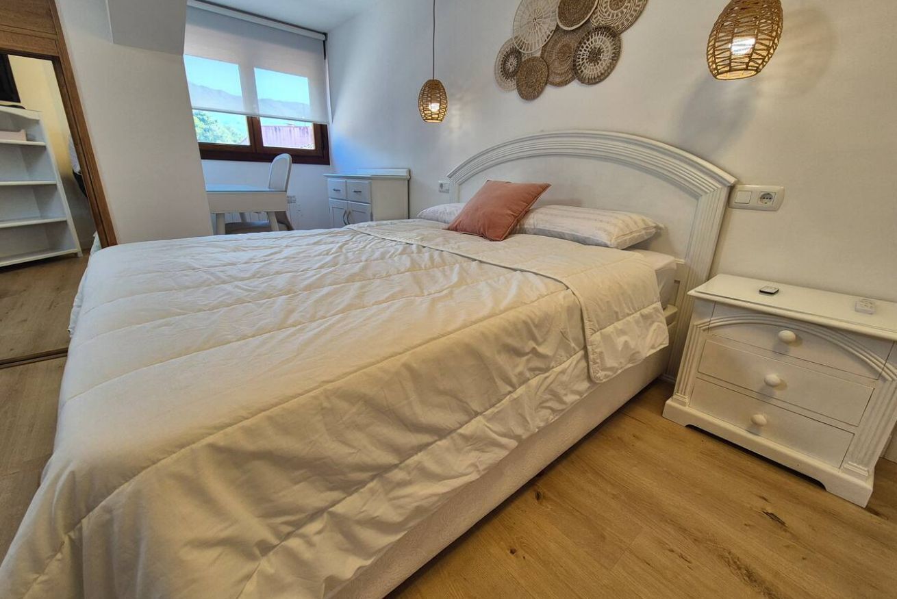 Ein Schlafzimmer mit einem Bett, einem Nachttisch und einem Schreibtisch mit Stuhl.