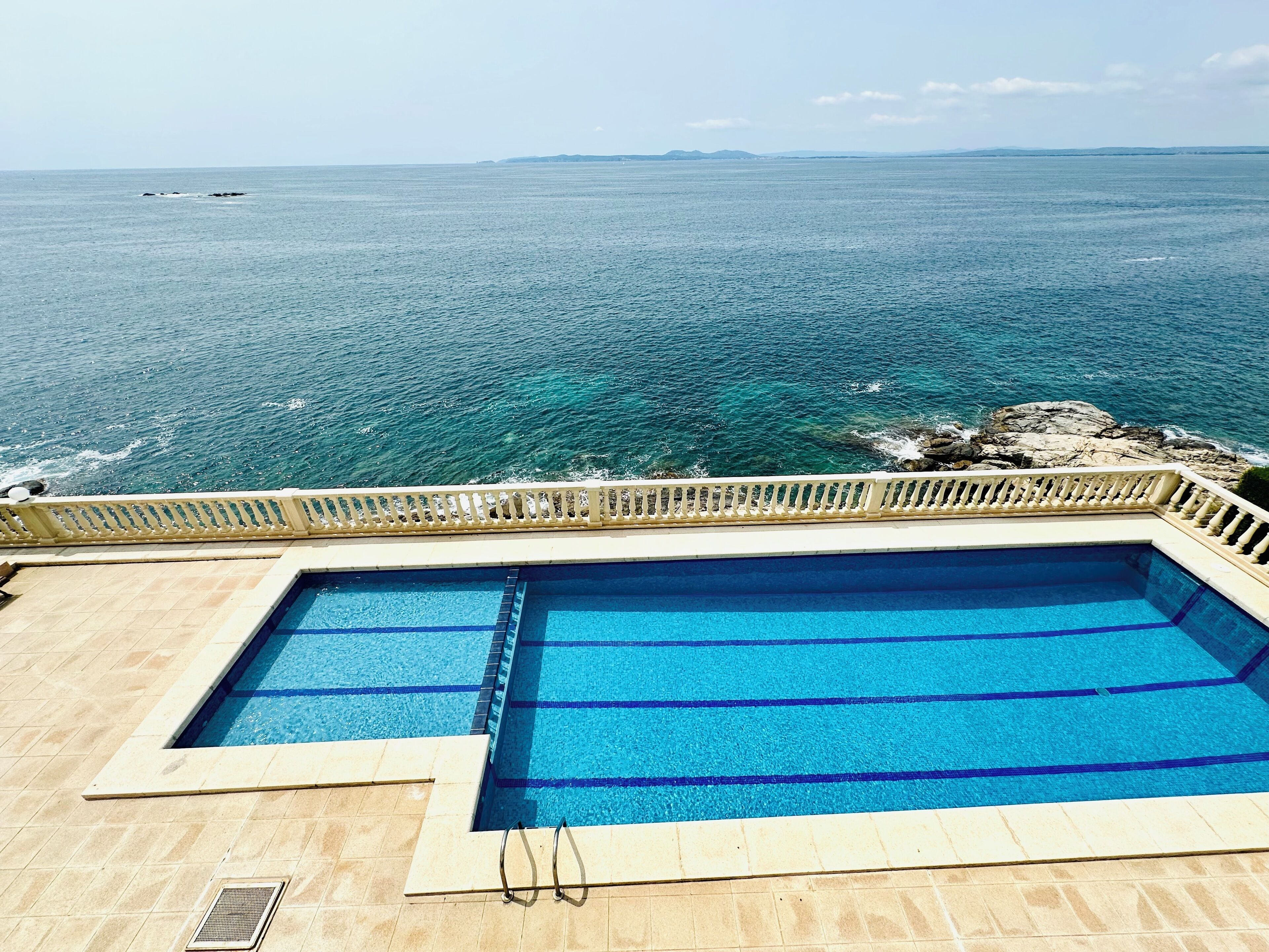 A pool with clear blue water and a view of the ocean.