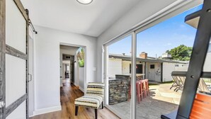 Una habitación amplia con un gran ventanal corredero que da a un patio exterior.