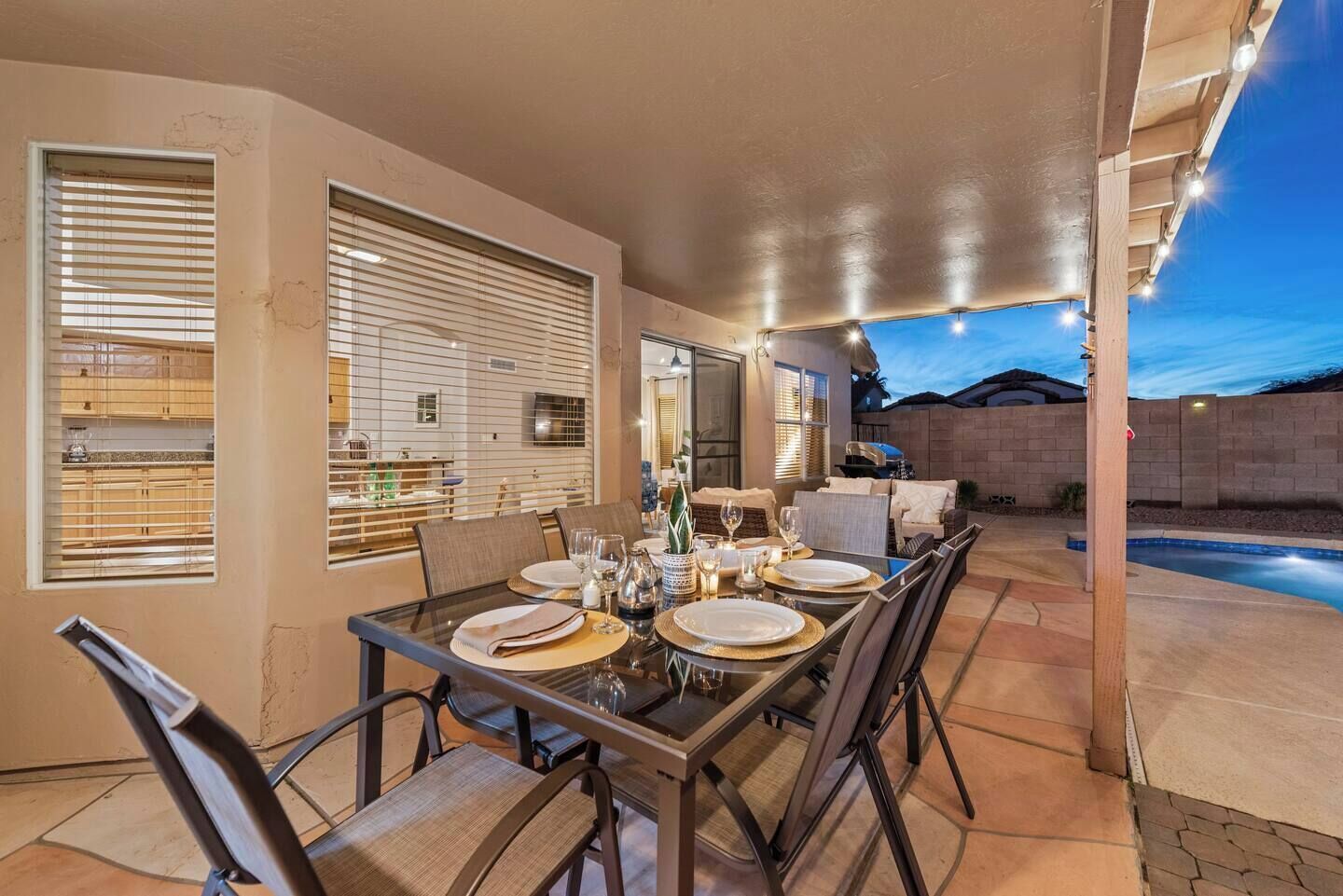 Un espace extérieur aménagé pour les repas, avec une table dressée pour quatre personnes, entourée de chaises.