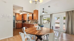 A spacious kitchen with wooden cabinets and a dining area with a round table and white chairs. - PRIVATE OASIS with the BEST backyard!!! (Phoenix)