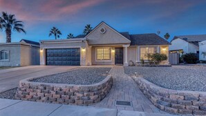 A modern two-story house with a garage, a well-lit front door, and a landscaped front yard with stone planters. - PRIVATE OASIS with the BEST backyard!!! (Phoenix)