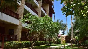 A multi-story building with balconies, surrounded by well-maintained greenery and a clear sky. - Charming apartment on Cumbuco Beach, Ceara, Brazil (Praia de Cumbuco Caucaia)