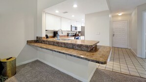 A modern kitchen with white cabinets, granite countertops, and stainless steel appliances. - Cozy 2-bedroom apartment in charming Orlando with AC, WiFi (Orlando)