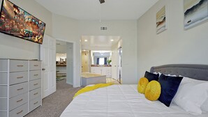 A bedroom with a large bed, a dresser, and a painting on the wall. - Cozy 2-bedroom apartment in charming Orlando with AC, WiFi (Orlando)